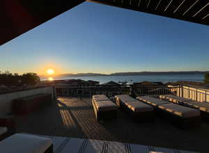 Deck at dusk featuring a water and mountain view