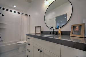 Full bathroom featuring shower / tub combo with curtain, vanity, and toilet