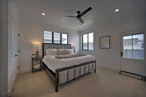 Carpeted bedroom featuring ceiling fan