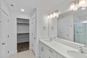 Bathroom with tile patterned flooring, vanity, and a shower with shower door