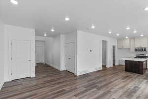 Kitchen featuring dark wood-type flooring, a kitchen island, and stainless steel appliances