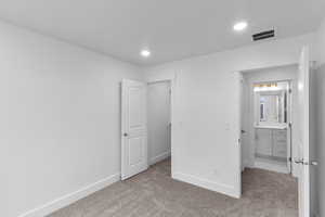 Unfurnished bedroom with light carpet and sink