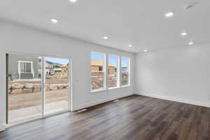 Spare room with a healthy amount of sunlight and dark hardwood / wood-style floors