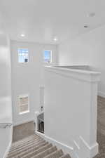 Stairs with carpet flooring and plenty of natural light
