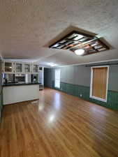 Unfurnished living room featuring wood-type flooring and a textured ceiling