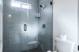 Bathroom featuring an enclosed shower and toilet