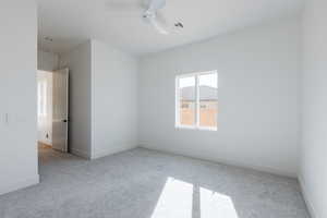 Spare room featuring ceiling fan and light carpet