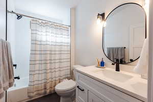 Full bathroom featuring tile patterned flooring, vanity, toilet, and shower / bath combo with shower curtain