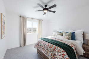 Carpeted bedroom with ceiling fan and vaulted ceiling