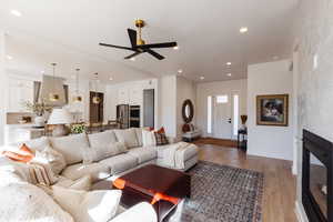 Living room with light hardwood / wood-style floors and ceiling fan