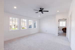 Empty room with light colored carpet and vaulted ceiling