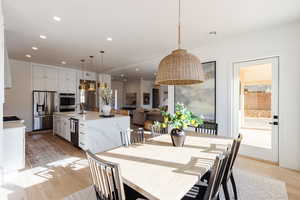 Dining area with sink and light wood-type flooring