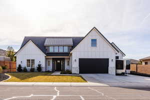 Modern inspired farmhouse with a garage and a front lawn