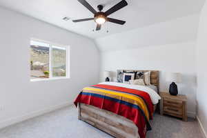 Bedroom with carpet flooring, ceiling fan, and vaulted ceiling