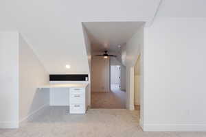 Interior space with ceiling fan, light colored carpet, and lofted ceiling