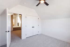 Additional living space with carpet flooring, ceiling fan, and lofted ceiling