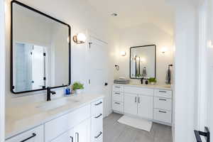 Bathroom with vanity and lofted ceiling