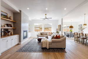 Living room featuring ceiling fan, plenty of natural light, and light hardwood / wood-style floors