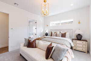 Bedroom featuring carpet flooring, connected bathroom, and a chandelier