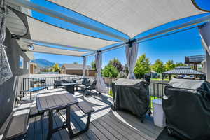 Wooden deck featuring area for grilling, a mountain view, and an outdoor hangout area