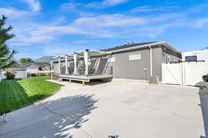 Back of house with a yard, cooling unit, and a mountain view