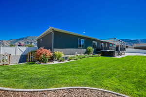 Back of property with a mountain view, a patio area, and a yard