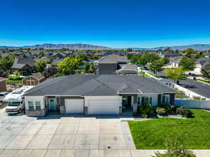 Single story home with a mountain view, a garage, and a front yard