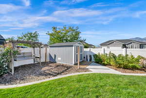 View of yard with a pergola and a shed