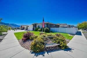 View of property exterior with a mountain view, a garage, and a lawn