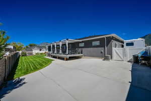 Back of property featuring a deck with mountain view and a lawn