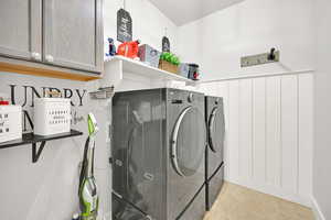 Washroom featuring cabinets and washing machine and clothes dryer