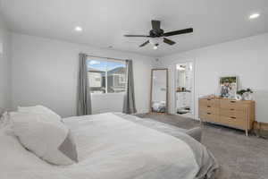 Bedroom 1 featuring carpet flooring, ceiling fan, and ensuite bath.