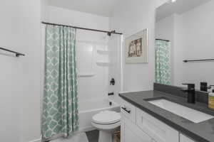 Full bathroom featuring vanity, toilet, and shower / tub combo.