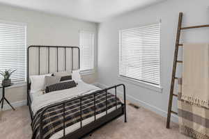 Bedroom featuring light carpet