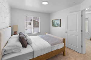 Bedroom featuring light carpet and a closet