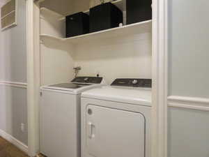 Washroom with washer and clothes dryer and carpet