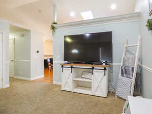 Carpeted living room featuring lofted ceiling