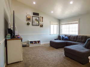 Living room featuring carpet flooring and vaulted ceiling