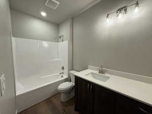 Full bathroom featuring shower / tub combination, vanity, wood-type flooring, and toilet