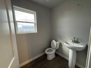 Bathroom with hardwood / wood-style flooring, sink, and toilet