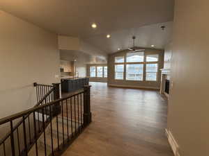 Hallway with hardwood / wood-style flooring and lofted ceiling