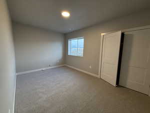 Unfurnished bedroom featuring light colored carpet