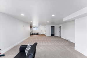 Unfurnished living room featuring light carpet