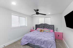 Carpeted bedroom featuring ceiling fan