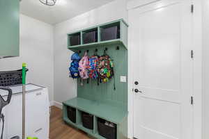 Mudroom with washer and clothes dryer and light hardwood / wood-style floors