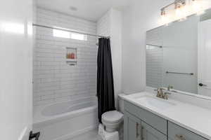 Full bathroom with vanity, toilet, and shower / bath combo with shower curtain