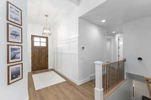 Foyer entrance with a chandelier and light wood-type flooring