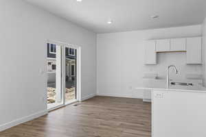 Kitchen with sink, white cabinets, and light hardwood / wood-style flooring