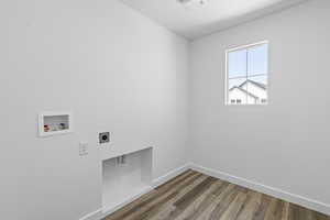 Laundry room with hookup for an electric dryer, hookup for a washing machine, and dark wood-type flooring