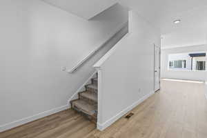 Stairway with wood-type flooring and a textured ceiling